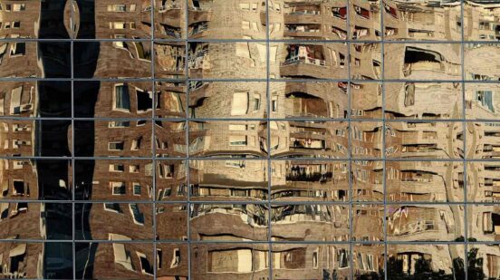 Residential buildings reflect on the windows of an office building in Belgrade