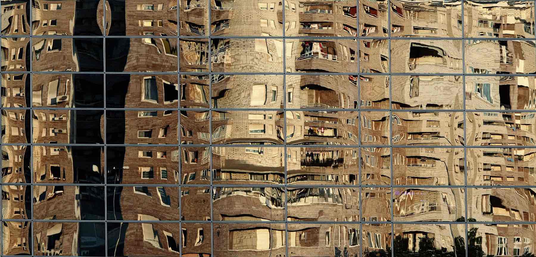 Residential buildings reflect on the windows of an office building in Belgrade