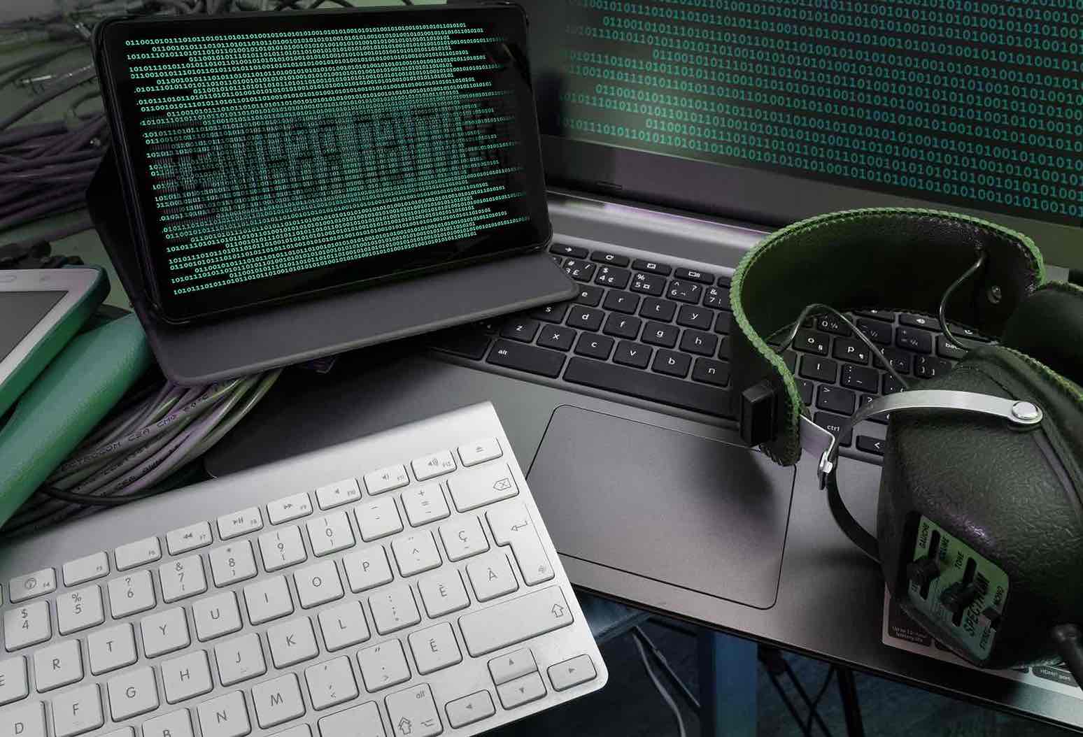 Binary codes on the screens of the computer and tablette, a headphone as well