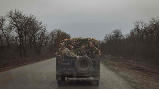 Ukrainian servicemen drive in a military vehicle