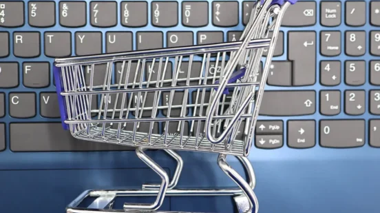 kolica za kupovinu ispred tastature kao ilustracija za e-trgovinu i online shopping