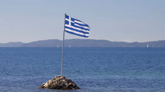 zastava Grčke na plaži kao ilustracija letovanja