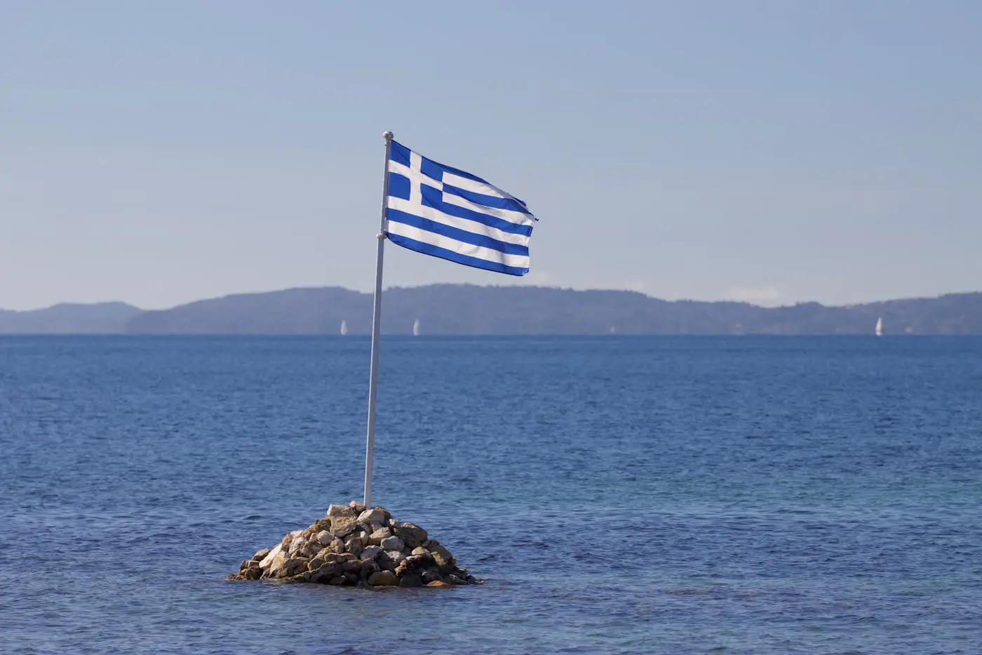 zastava Grčke na plaži kao ilustracija letovanja