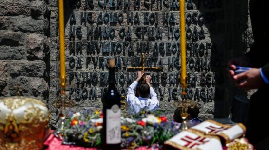 A Serbian man holds a crucifix as he takes part in a ceremony marking the historic 