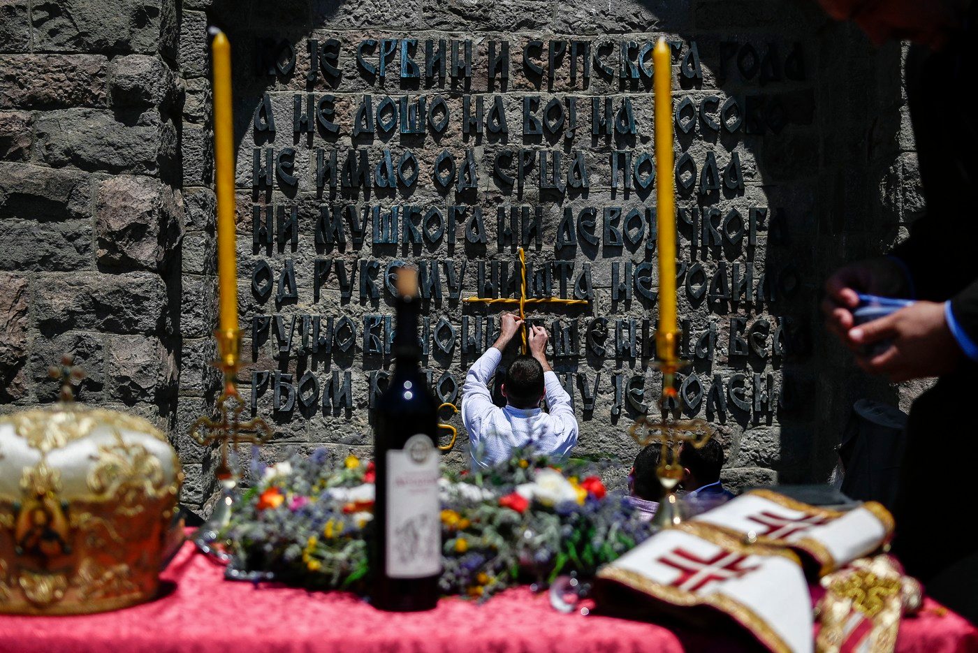 A Serbian man holds a crucifix as he takes part in a ceremony marking the historic 