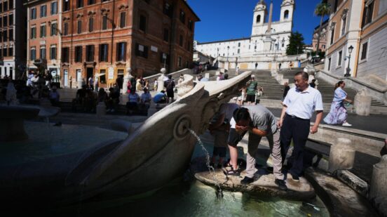 People refresh at the Barcaccia Fountain in front of Rome's Spanish Steps, Wednesday, July 15, 2026. (AP Photo/Andrew Medichini)