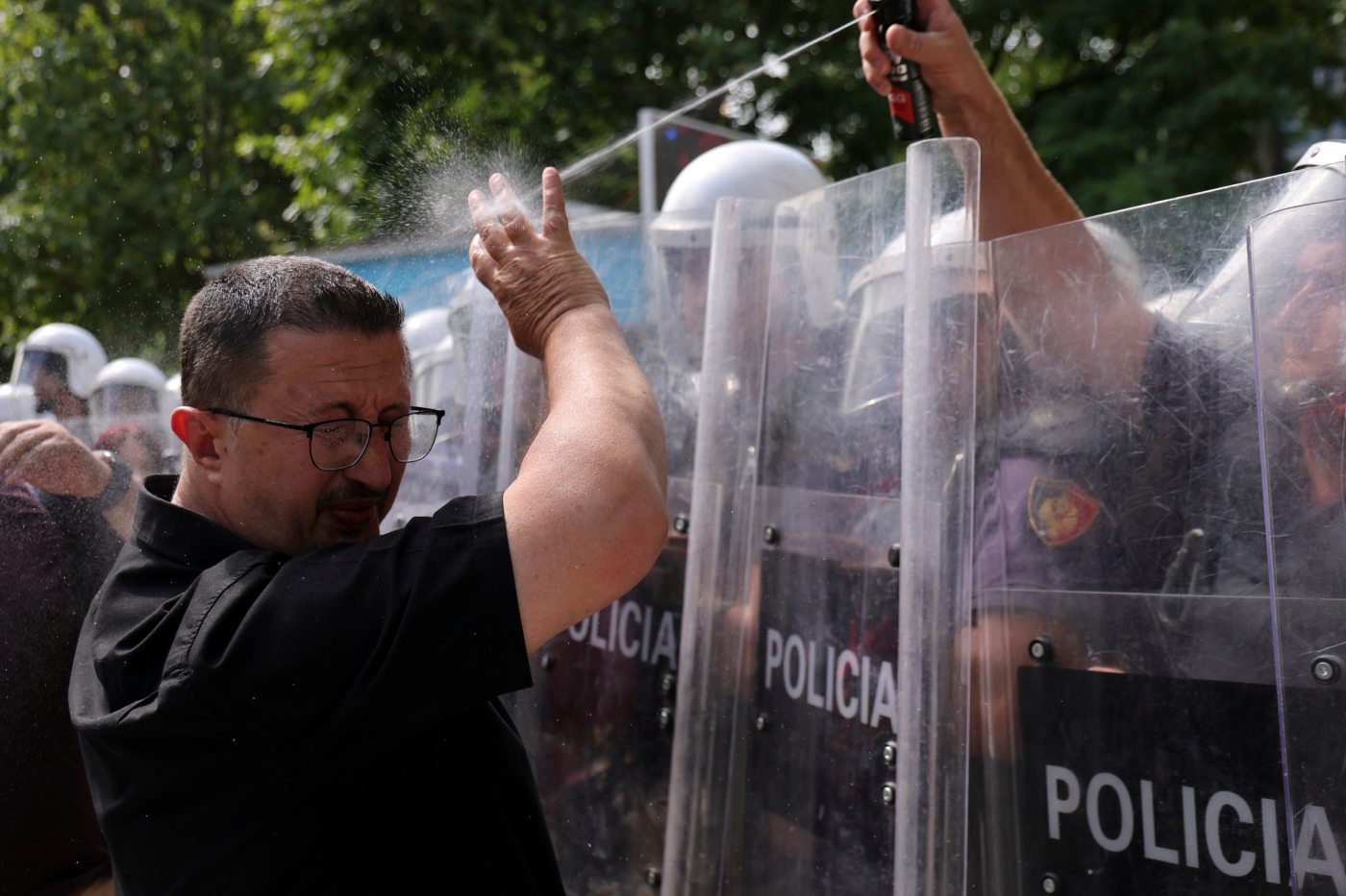 A riot police officer uses pepper spray against a protester during clashes at an anti-government rally in Tirana, Albania, Thursday, July 2, 2026. (AP Photo/Hameraldi Agolli)