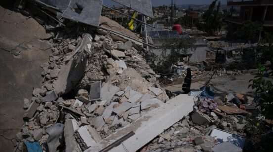 Fatima Mokdad walks through the rubble of her home, which was destroyed in an Israeli airstrike during the Israel-Hezbollah war, where she and her family continue to live, using the only room that remained intact, in Froun village, southern Lebanon, Tuesday, July 21, 2026. (AP Photo/Hassan Ammar)
