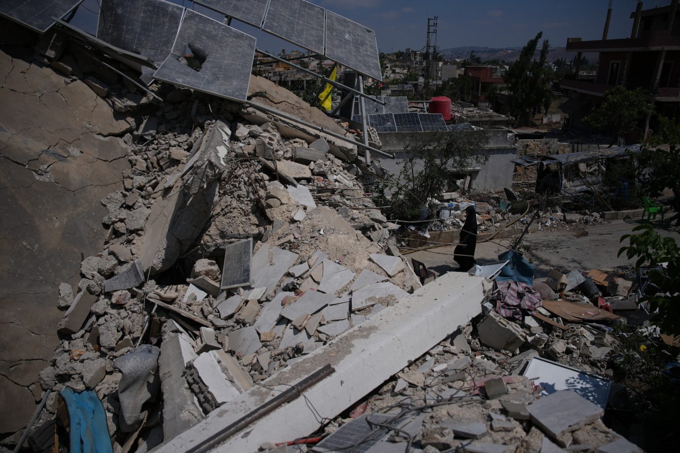 Fatima Mokdad walks through the rubble of her home, which was destroyed in an Israeli airstrike during the Israel-Hezbollah war, where she and her family continue to live, using the only room that remained intact, in Froun village, southern Lebanon, Tuesday, July 21, 2026. (AP Photo/Hassan Ammar)